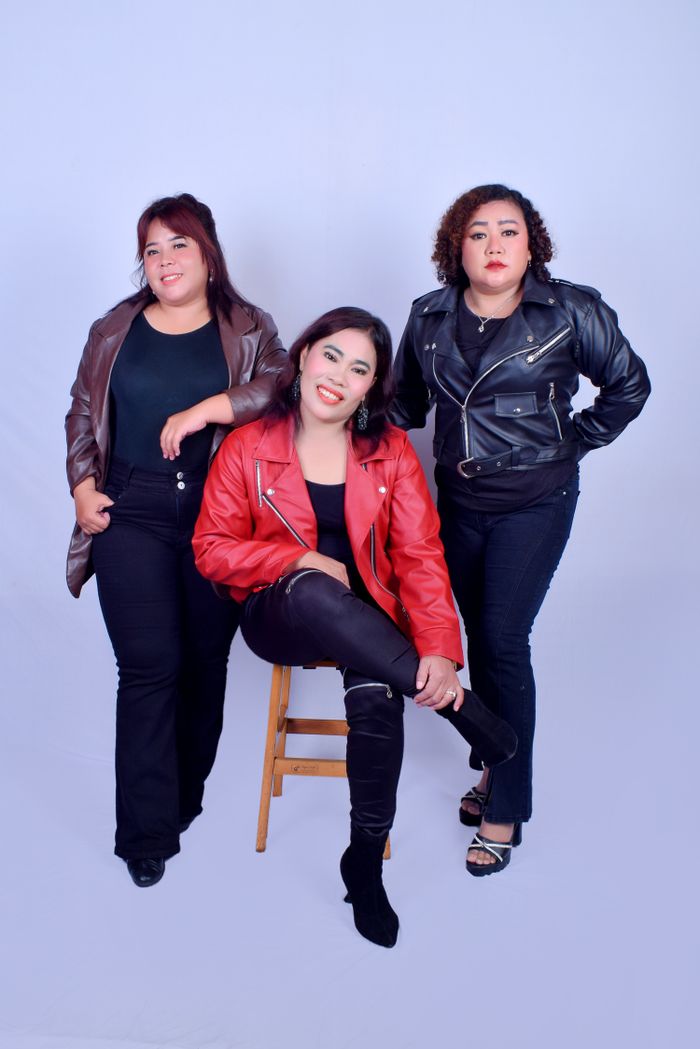 services-02 Three confident women posing together in leather jackets against a studio backdrop.